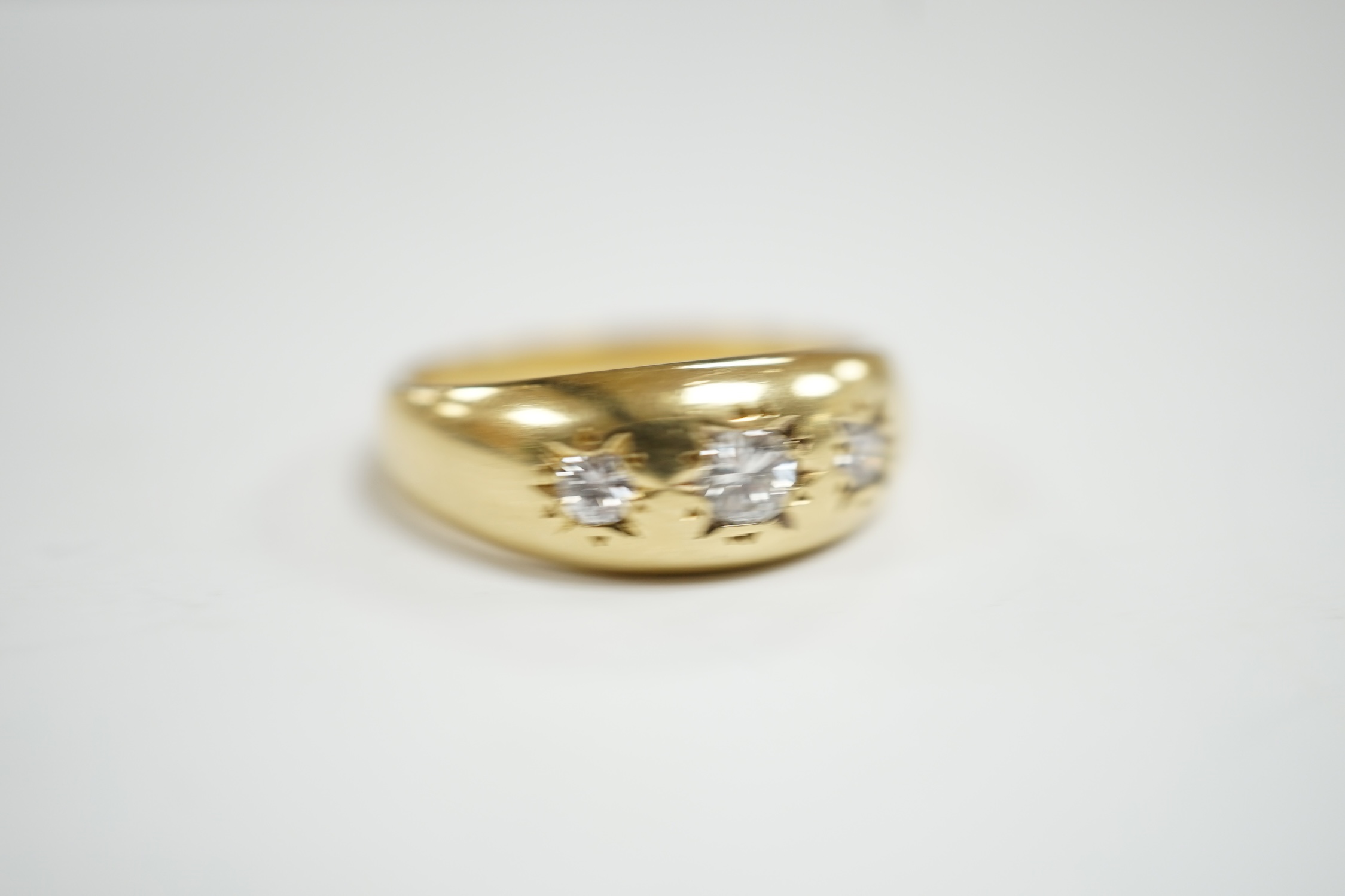 A modern 18ct gold and gypsy set three stone diamond ring, size S, gross weight 7.9 grams.